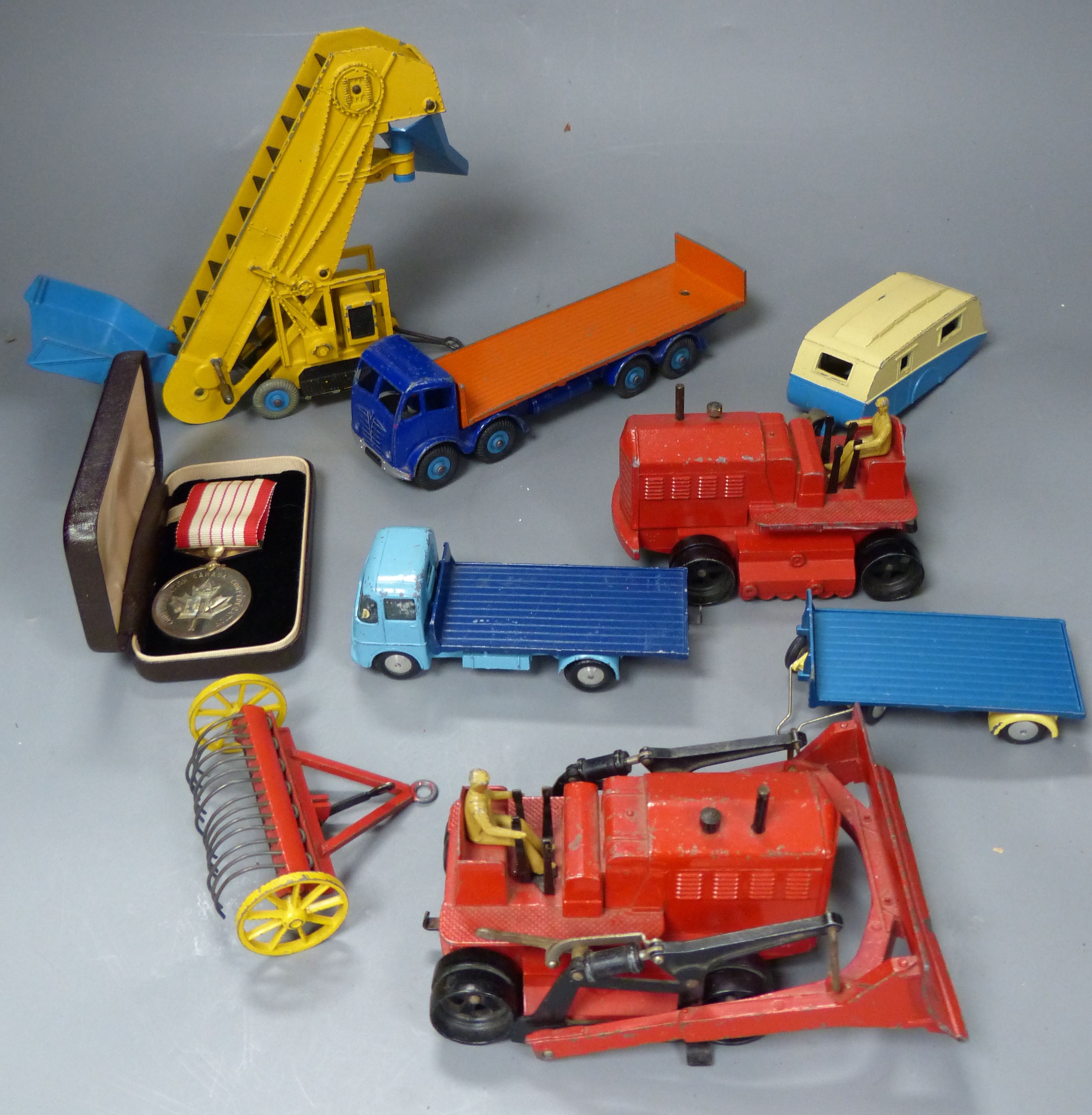 A group of mixed diecast to include Dinky and Corgi toy diggers, tractors, etc. 7 items and a commemorative Canadian medal